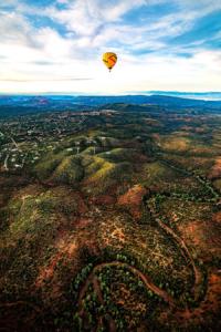 Hot air balloons floating over Sedona in the early morning